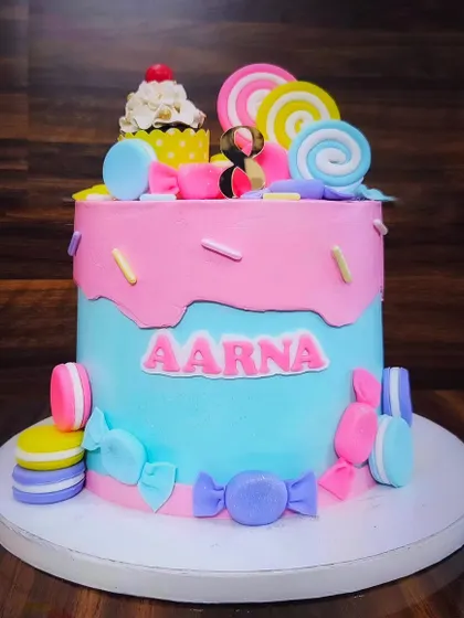 Welcome to Candyland! A pink and blue cake for Aarna's 8th birthday, decorated with macarons, lollipops, and other sweet treats.