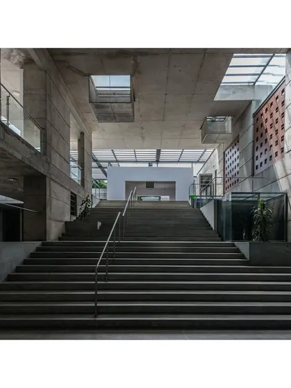 An interior view of the grand staircase in the classroom complex, showing how skylights create square patterns of light. This is a subtle detail that situates the building in a newer time period than the original structures.