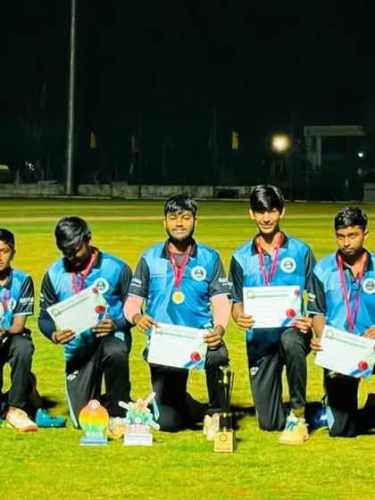 The runner-up team kneels with their certificates and medals after the final of a night tournament.