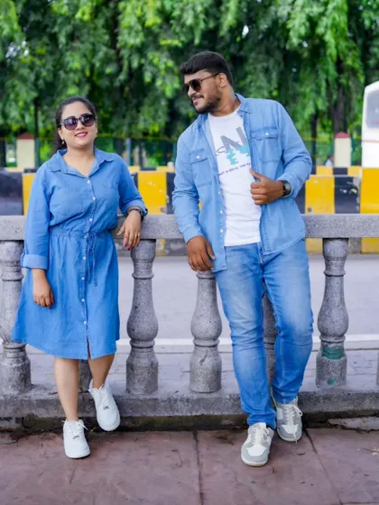 A stylish urban shot of a couple in matching denim outfits, leaning against a railing. It's all about capturing your style as a couple.