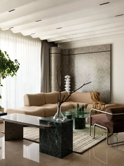 The living area, designed for relaxation and conversation. The custom sofa, marble bench, and unique coffee table are arranged to create a welcoming and sophisticated setting.