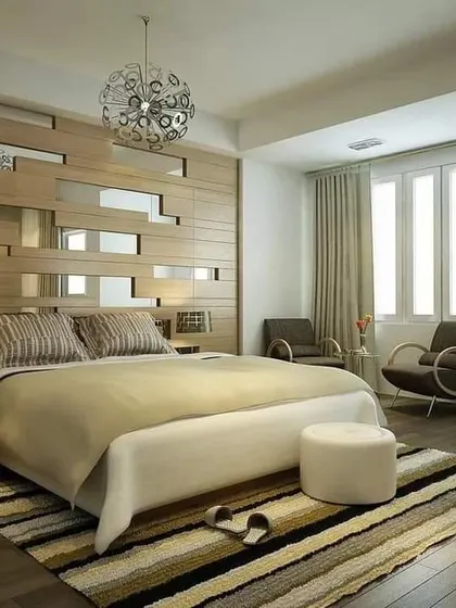 A unique bedroom design featuring a wood-paneled accent wall with integrated mirror strips. This adds visual interest and reflects light, making the room feel more dynamic and spacious.