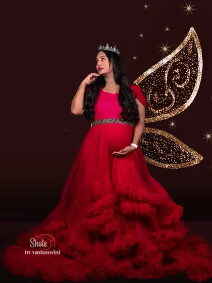 Feel like a fairy tale princess in this red ruffle gown, complete with sparkling fairy wings for a magical maternity photoshoot.