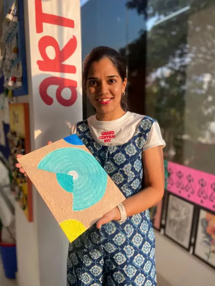 A participant with her finished abstract texture painting. The combination of colors and patterns creates a unique and modern piece.