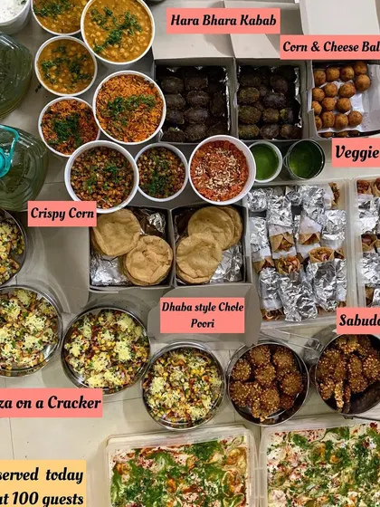 A massive dinner spread for about 100 guests. This order featured a wide array of starters and mains, including Hara Bhara Kebab, Veggie Frankie, Dhaba style Chole Poori, and Pizza on a Cracker.