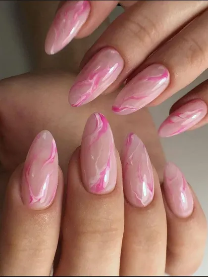A beautiful pink quartz or marble effect on long almond nails.