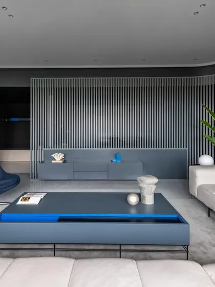 Another view of the living room in 'A Hint of Azul', highlighting the custom coffee table and credenza. The blue accents in the furniture tie back to the project's name and conceptual theme.