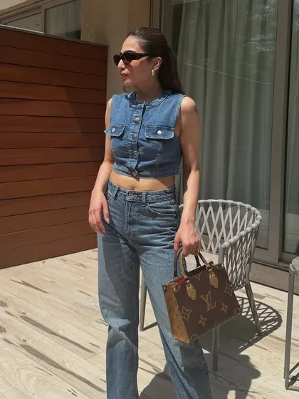 A sunny day look featuring a denim vest and jeans. A perfect example of a spring or summer denim-on-denim outfit.