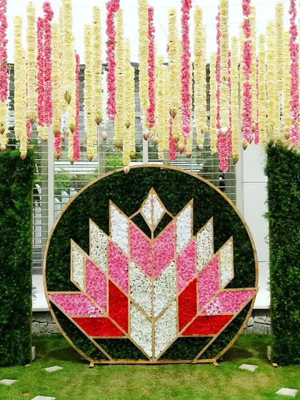 A modern naming ceremony backdrop with a geometric lotus design made of flower petals.