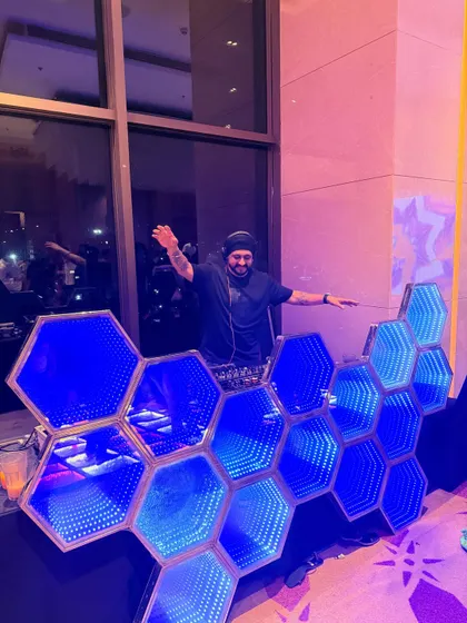 Waving to the crowd after a non-stop 5-hour music set. The custom hexagonal LED booth looks fantastic with its deep blue infinity mirror effect.