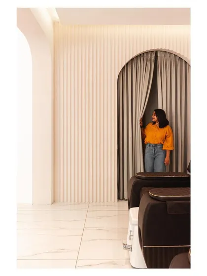 A peek through a curtained archway hints at the private, tranquil spaces within the salon.