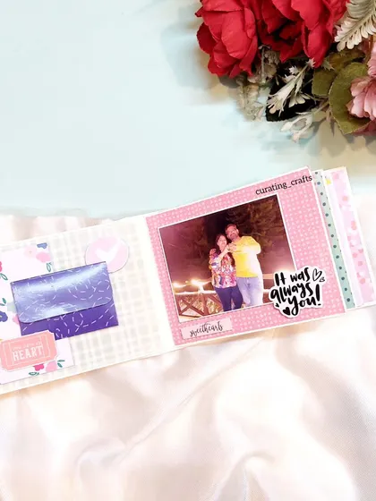 An inside page of a mini anniversary scrapbook, with a small pocket for a hidden note.