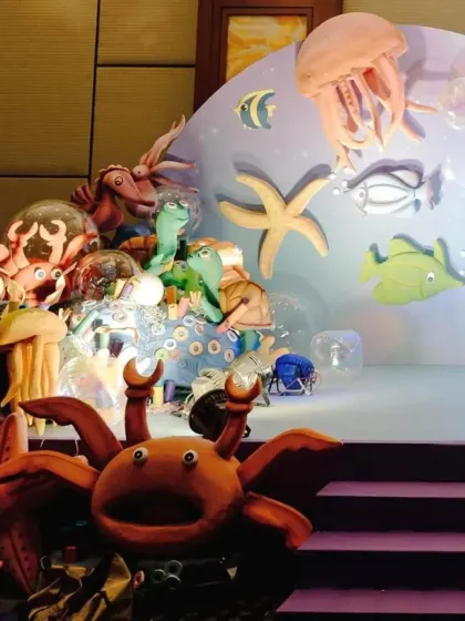 This stage setup for an underwater party is filled with a variety of sea creatures, creating a busy and vibrant ocean floor scene.