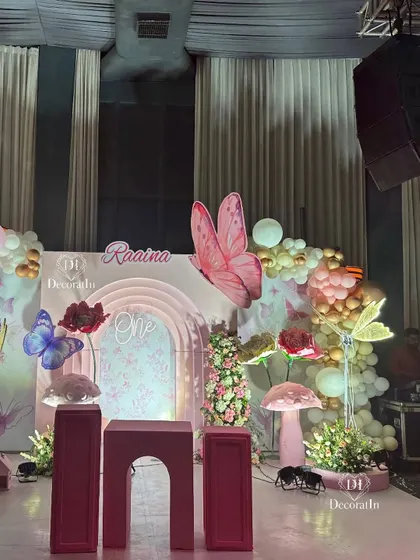 A slightly different angle of the main stage, capturing the full width of the balloon garlands and whimsical props.