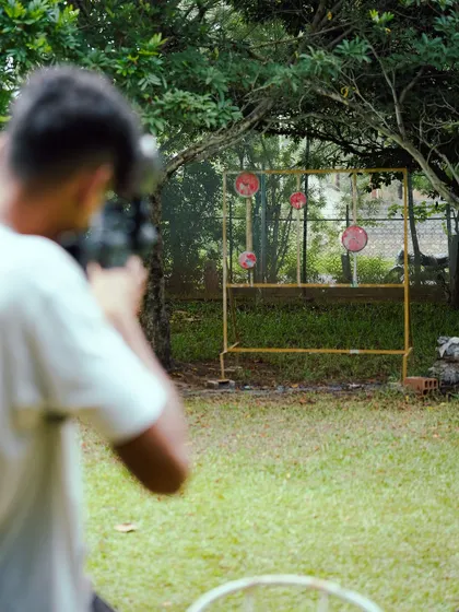 Concentration is key. A guest focuses intently on the targets, ready to test their accuracy with one of our paintball markers at the shooting range.