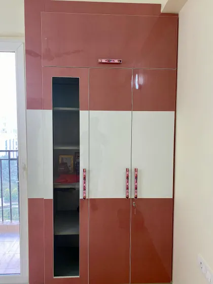 The exterior of the kids' wardrobe, featuring a pink and white design with a glass panel to display toys or books.