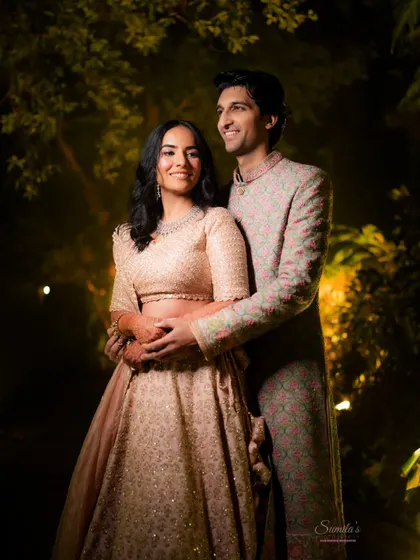 A beautiful couple portrait taken at night, with soft lighting creating a warm and romantic mood. This shot highlights their coordinated pastel outfits and happy expressions.