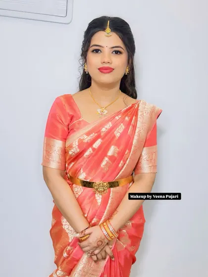 A lovely look in a peach-colored saree. The makeup is soft and glowing, with a simple hairstyle, making it perfect for a guest attending a wedding or a daytime event.