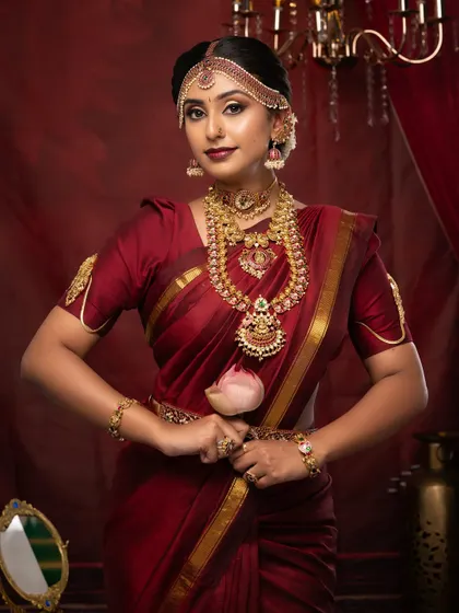 The final look of a South Indian bride, holding a lotus. This is the kind of portfolio-worthy shot our students create.
