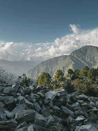 A pile of stones waits to be chiseled and placed, with the majestic mountains as a backdrop. This image speaks to the fundamental elements of our work: natural materials and an epic landscape.