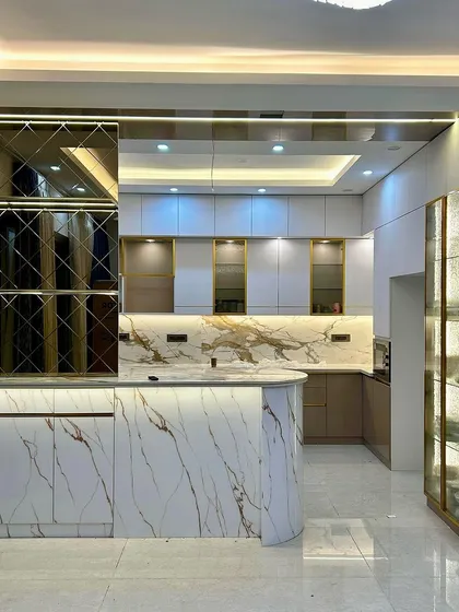 The completed version of the glamorous kitchen, perfectly realizing the 3D render with its marble island, mirrored backsplash, and elegant lighting.