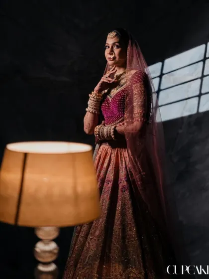 A beautifully lit portrait of the bride, showcasing the unique color palette of her Tarun Tahiliani lehenga. This is a look that is both artistic and personal.