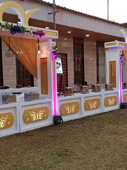 A white and gold themed buffet counter with butterfly motif lighting, designed for an elegant wedding reception.