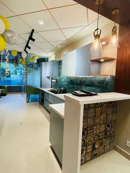 A modern kitchen display at the Indiranagar center, featuring a breakfast counter with unique decorative tiles.