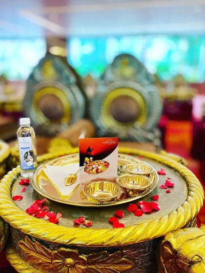 A close-up of the individual thali setup. Each guest receives a golden plate with matching bowls, ready to be filled with the many delicacies of Rajasthani cuisine.