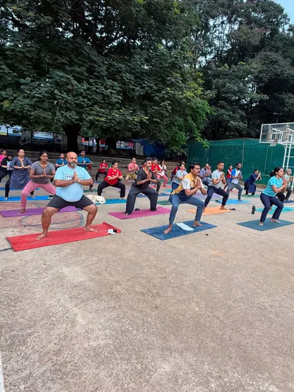 A group holds a strong Goddess Pose during an outdoor class, grounding their energy into the earth.