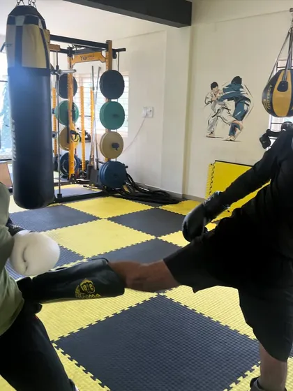 A female fighter practices a kick block during a kickboxing drill. We focus on practical techniques for both offense and defense.