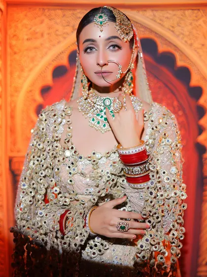 A portrait that captures the bride's confidence and grace. The emerald green jewellery adds a beautiful pop of colour against the ivory outfit.