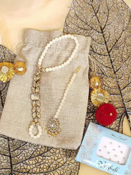 A beautiful Mehendi favour idea. This simple jute potli is filled with a delicate pearl and stone haath phool and a pack of bindis, making it a practical and pretty gift for your guests.