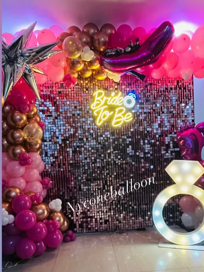 This shot highlights the key elements of the bachelorette party decor: the 'Bride to Be' neon sign, the light-up diamond ring, and the shimmering backdrop.