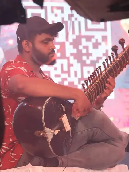 A side view of me playing at a modern event, with a QR code visible on the screen behind me. It's a great example of how ancient traditions meet today's technology.