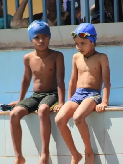 Swimmers waiting for their events by the poolside. The camaraderie and shared excitement are a huge part of our competition days and summer camps.