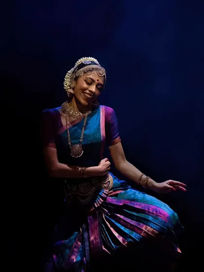 A moment of blissful dance, captured in a still shot. The lighting and costume colors create a vibrant and joyful image.