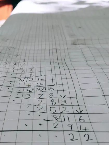 A close-up of the meticulous calculations involved in a massive long division problem. The child is not just finding an answer; she is exploring the process, checking her work, and experiencing the deep satisfaction of sustained focus.