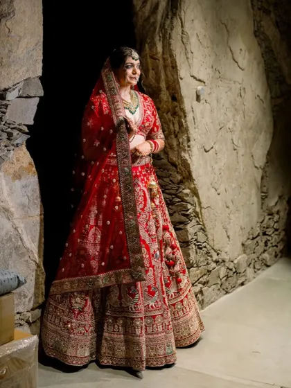 A full length shot of Divya's stunning bridal look. The makeup complements her grand lehenga without competing with it.
