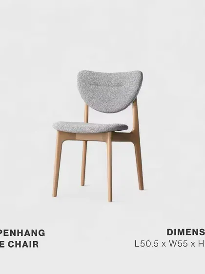 A studio shot of the Copenhang Side Chair. Its solid oak frame and luxurious grey boucle fabric upholstery embody exclusivity and refinement, making it a perfect companion to the Copenhang dining table.