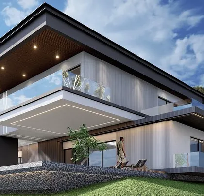 An alternate view of the modern farmhouse, showcasing the expansive glass walls and outdoor lounge areas. The design emphasizes indoor-outdoor living, a key feature of modern luxury homes.