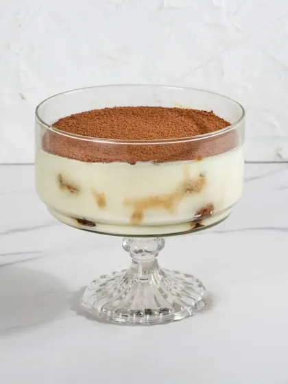 A clean, studio shot of our Classic Tiramisu in a glass dessert bowl, ready for gifting.