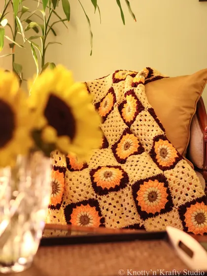 Adding some sunshiny warmth to counter the cold weather. This sunflower-themed granny square throw, with its rich oranges and yellows, is like a cozy hug on a chilly day.