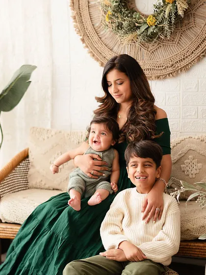 A joyful family photo with mom, big brother, and the baby all laughing together.