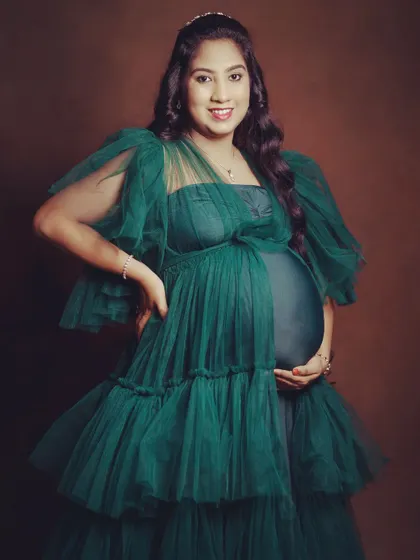 Feel like royalty in this emerald green layered tulle gown. The design includes a fitted inner dress that showcases your baby bump, with layers of soft tulle that add volume and elegance.