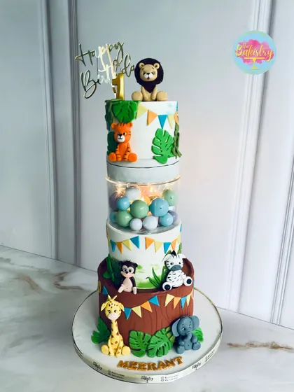 This jungle-themed cake for Meerant's first birthday is a safari adventure in every bite, featuring a magical light-up tier and cute animal figurines.
