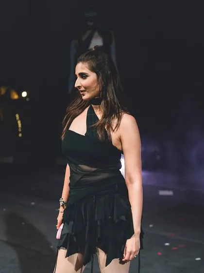A shot from the side of the stage. The dramatic lighting and smoky atmosphere make this custom black outfit look even more powerful.