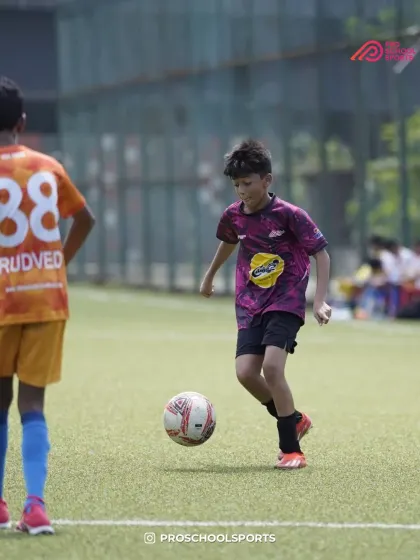 A young player dribbles with confidence, looking for a teammate to pass to.