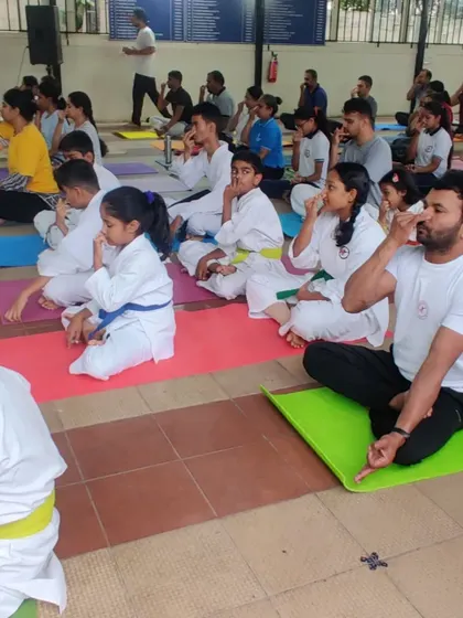 A mixed group of kids and adults engaged in a breathing exercise session. I believe mental fitness is just as important as physical fitness, and pranayama is a key part of that.