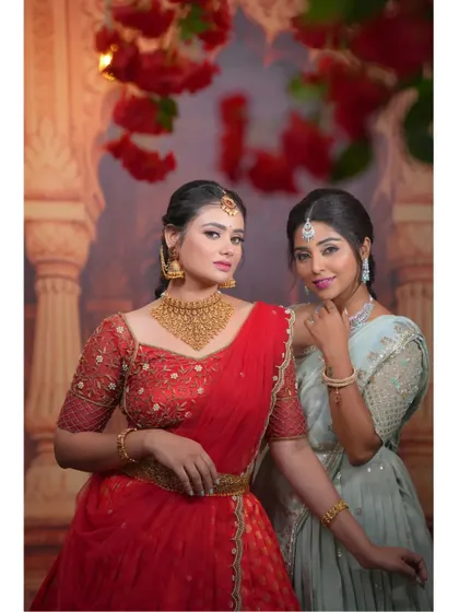 A lovely shot of two models wearing our hand-worked half-sarees in red and mint green. It's a great inspiration for bridesmaid or sister photoshoots.